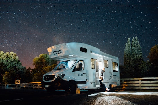 A RV at night with lights on and a family, perfect for a RV solar panel kit
