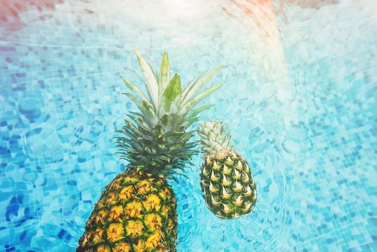 A pool with two pineapples heated by one of the best solar pool covers