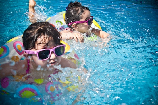 Kids swimming in a pool which is heated with the best solar pool heater