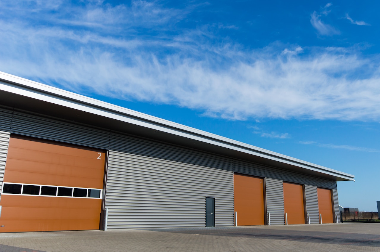new morton building storage warehouse with brown doors and blue sky